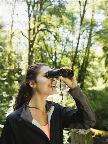 Portrait of woman looking at view with binoculars. USA, Oregon, Portland.
