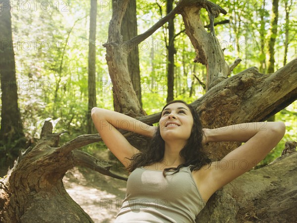 Portrait of young woman lying down on log. USA, Oregon, Portland.