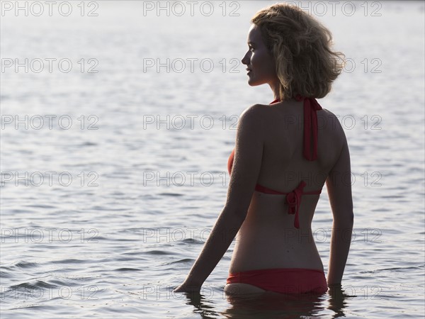 Beautiful woman standing in lake at sunrise.
Photo : Jan Scherders