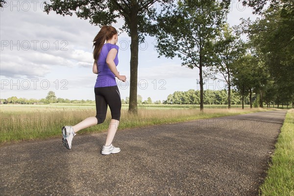 Woman jogging on road. The Netherlands, Erp.
Photo : Mark de Leeuw