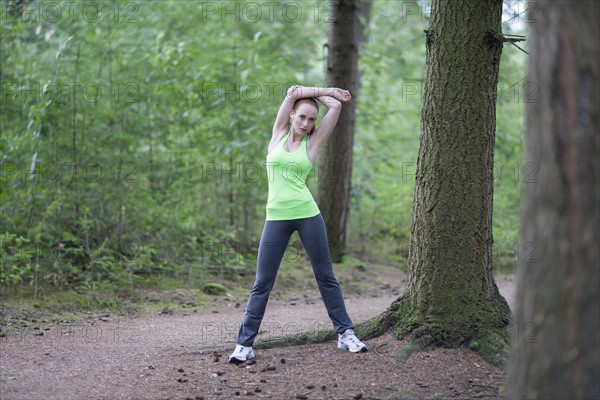 Woman stretching in forest. The Netherlands, Erp.
Photo : Mark de Leeuw