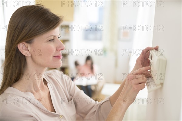 Woman adjusting house alarm.