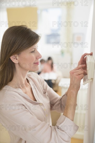 Woman adjusting house alarm.