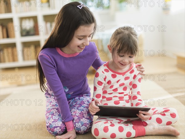 Two sisters (4-5, 8-9) using tablet pc.
