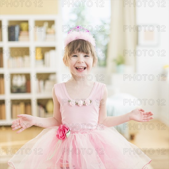 Girl (4-5) wearing tutu dancing in living room.