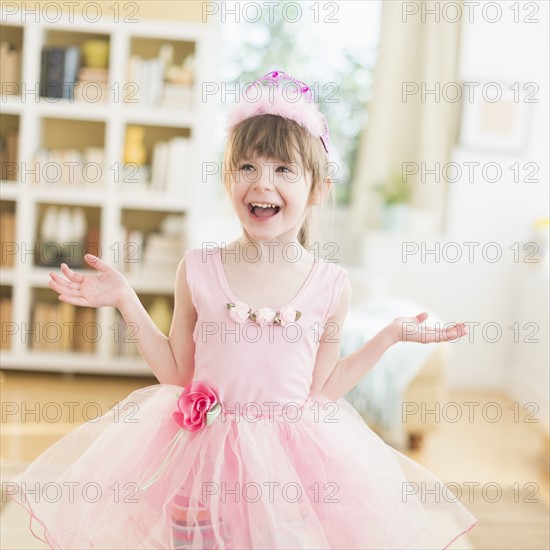 Girl (4-5) wearing tutu dancing in living room.