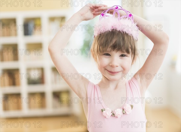 Girl (4-5) wearing tutu dancing in living room.