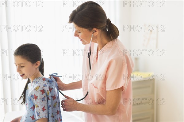 Doctor examining girl (8-9).