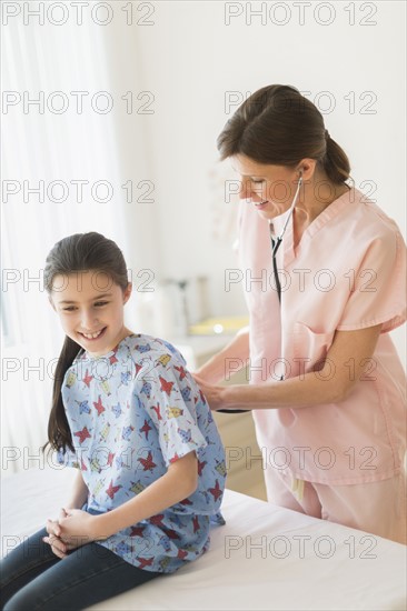 Doctor examining girl (8-9).