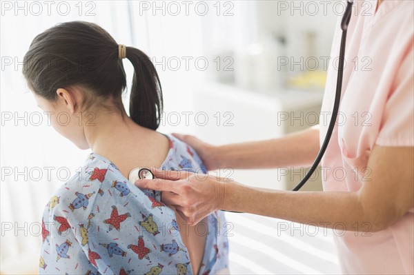 Doctor examining girl (8-9).