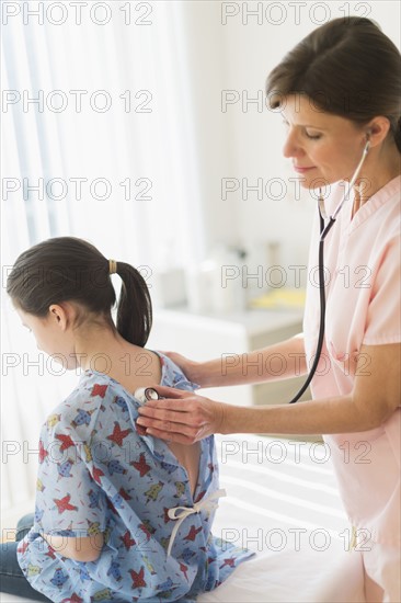 Doctor examining girl (8-9).