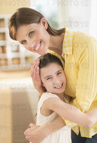 Portrait of mother and daughter (8-9) hugging.