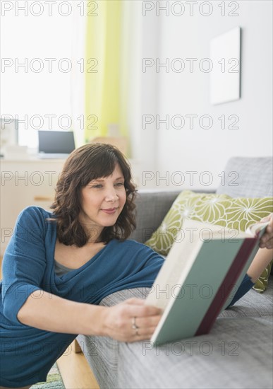 Woman reading book at home.