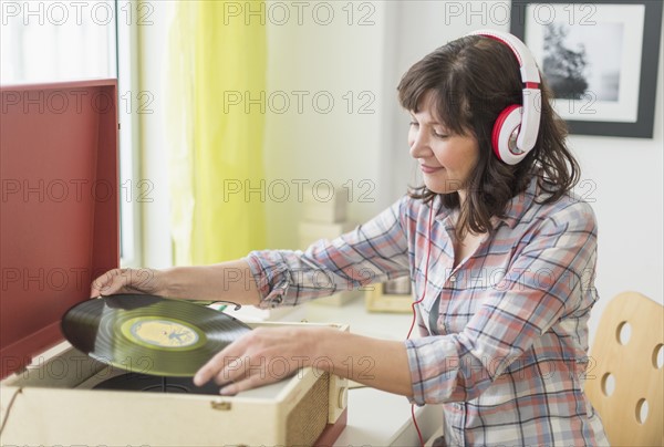 Woman listening to music on antique record player.