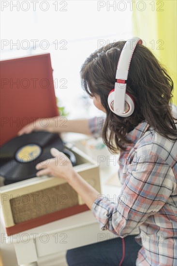 Woman listening to music on antique record player.