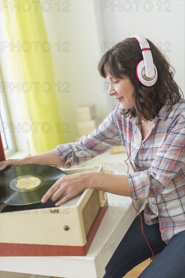 Woman listening to music on antique record player.