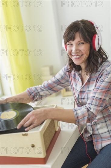 Woman listening to music on antique record player.