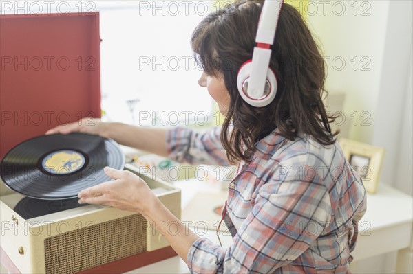 Woman listening to music on antique record player.