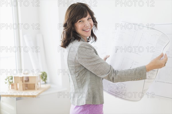 Female architect holding blueprints.