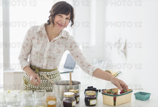 Woman making preserves in kitchen.