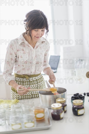 Woman making preserves in kitchen.