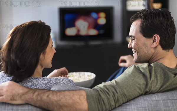 Rear view of couple watching tv.