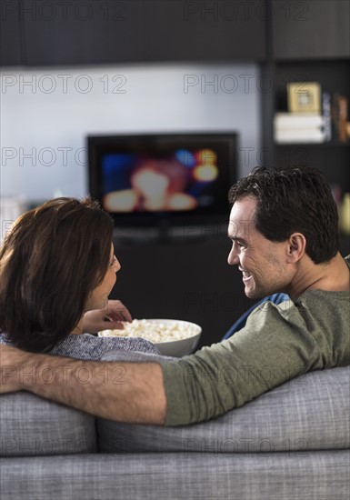 Rear view of couple watching tv.