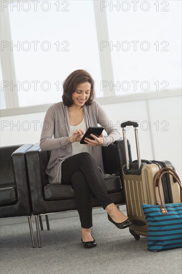 Female tourist using tablet pc at airport.