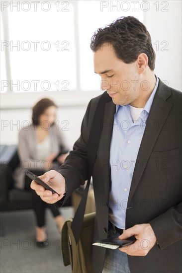 Businessman texting at airport.