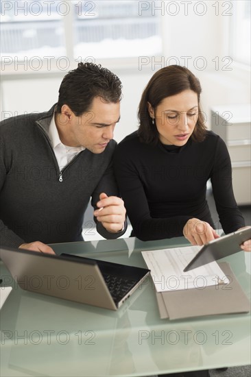 Businessman and businesswoman working in office.