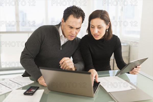 Businessman and businesswoman working in office.