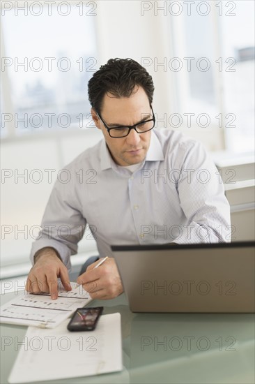 Businessman using laptop and digital tablet.