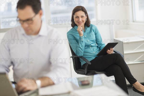 Businessman and businesswoman working in office.