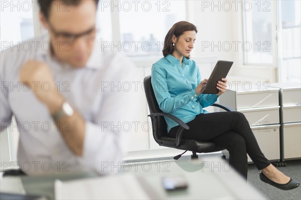 Businessman and businesswoman working in office.