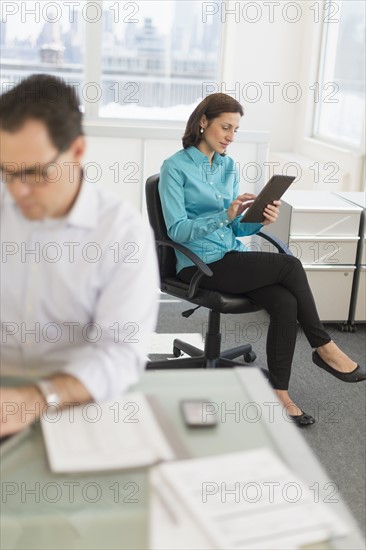 Businessman and businesswoman working in office.