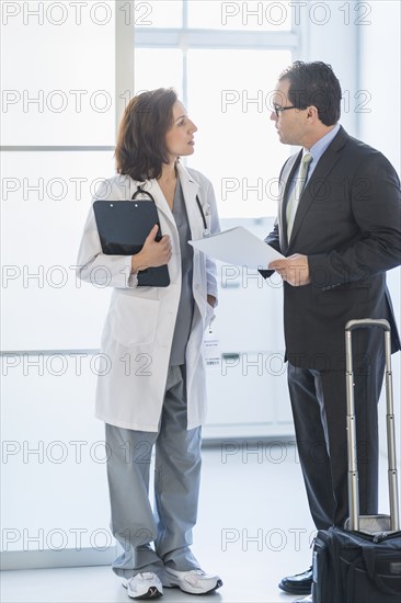 Pharmaceutical representative talking to female doctor.