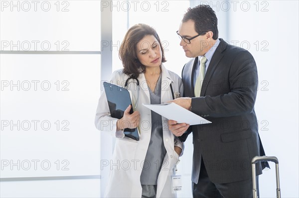 Pharmaceutical representative talking to female doctor.