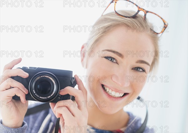 Portrait of woman holding camera.