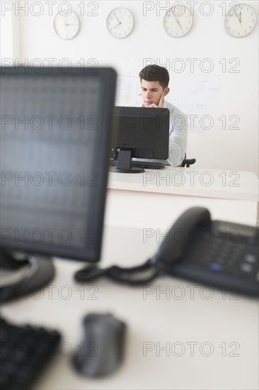 Young man sitting in front of desk and working.