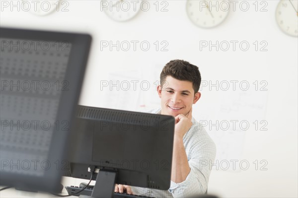 Young man sitting in front of desk and working.