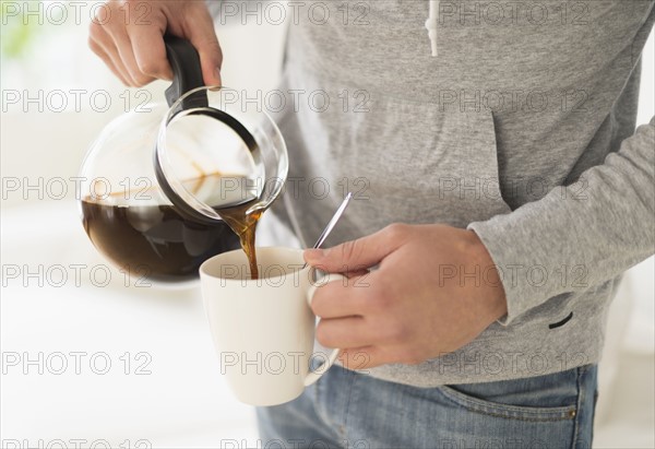 Young man pouring coffee.