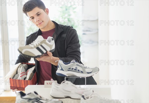 Young man looking at trainers in shoe shop.