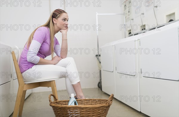 Woman waiting in laundromat.