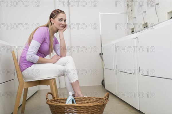 Woman waiting in laundromat.