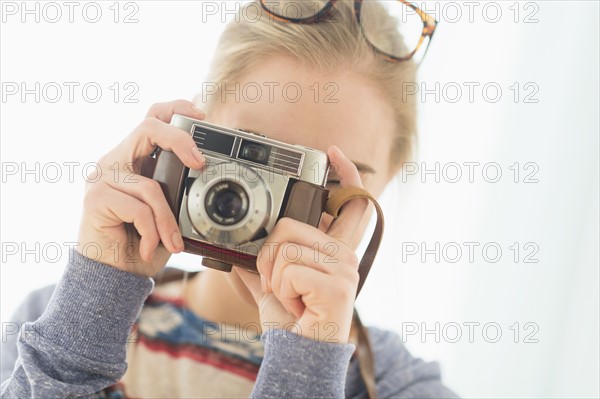 Woman looking through vintage camera.