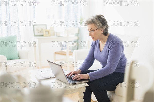 Mature woman paying bills via internet.