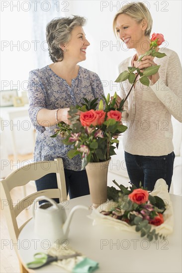 Two women arranging bouquet.