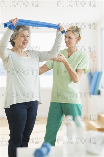 Mature woman exercising with personal trainer.