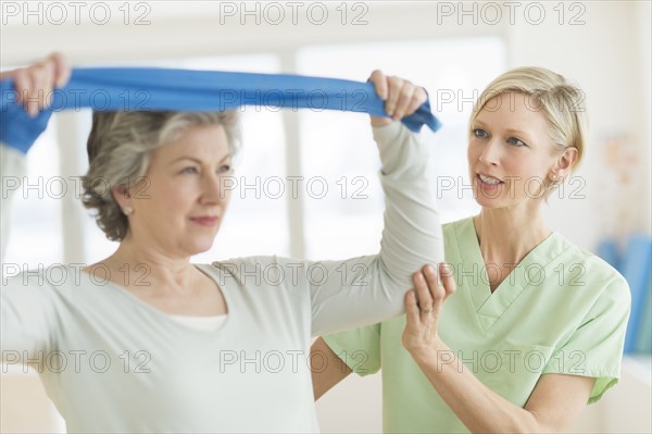 Mature woman exercising with personal trainer.