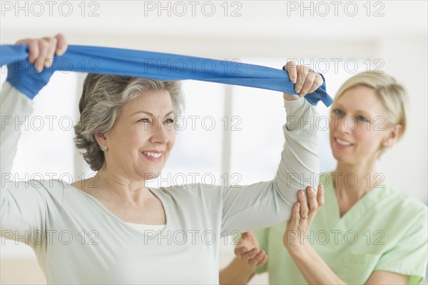 Mature woman exercising with personal trainer.